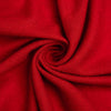 A close-up of bright red cashmere arranged in a spiral drape, showing the material texture and color.