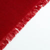 A close-up of a deep red woven cashmere  with fringed edges, shown diagonally against a plain white background.