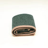 A folded dark green textured fabric item with a light pink ribbed border, shown on a clean white background.
