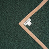 Close-up of a dark green textured knit fabric with a contrasting light pink ribbed trim and a visible white