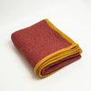 Terracotta Heather cashmere throw blanket with Golden Ochre trim, folded