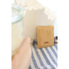 Reusable bamboo kitchen scraper beside sink